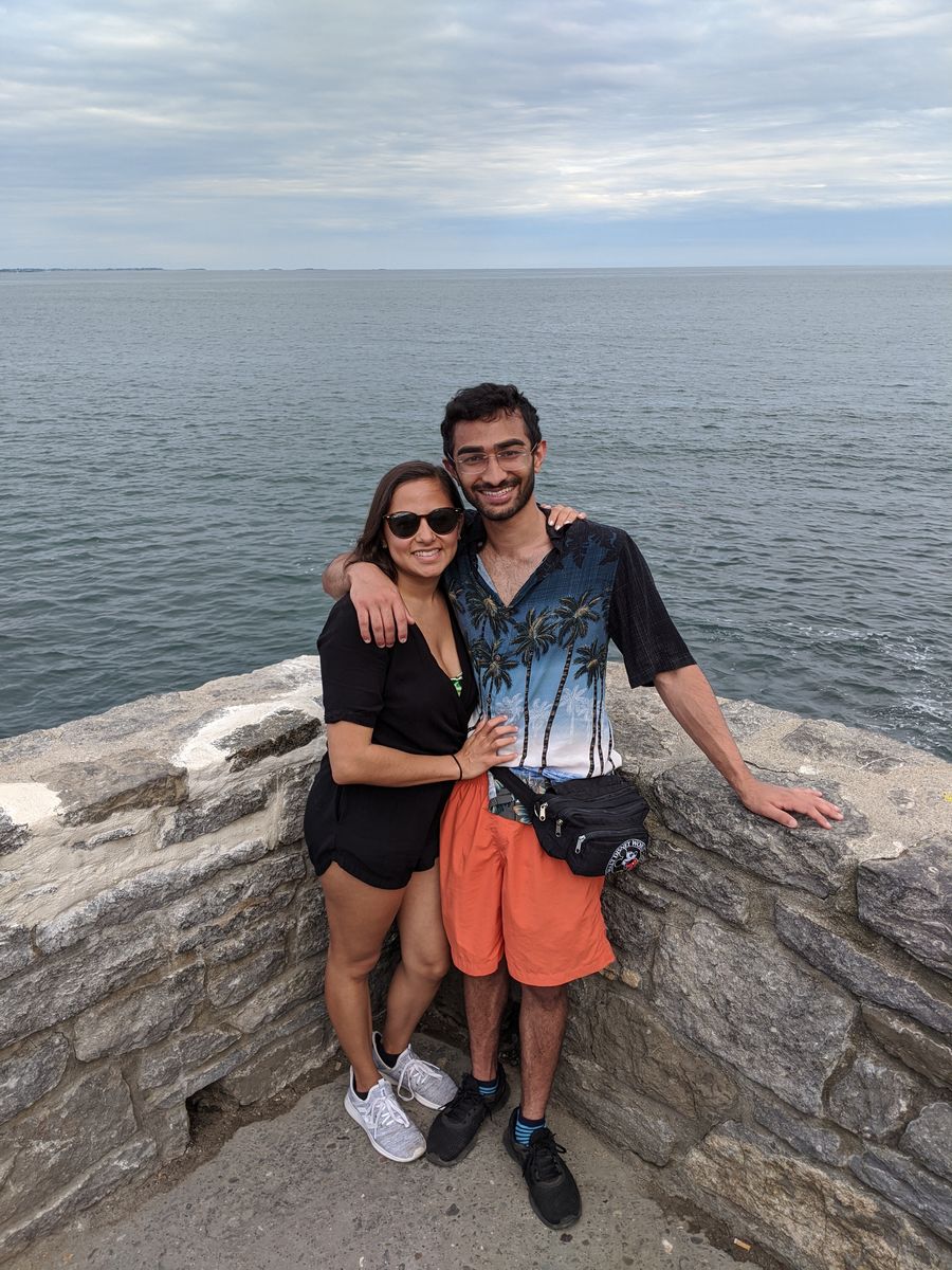 Couple sitting on a stone seawall by the ocean